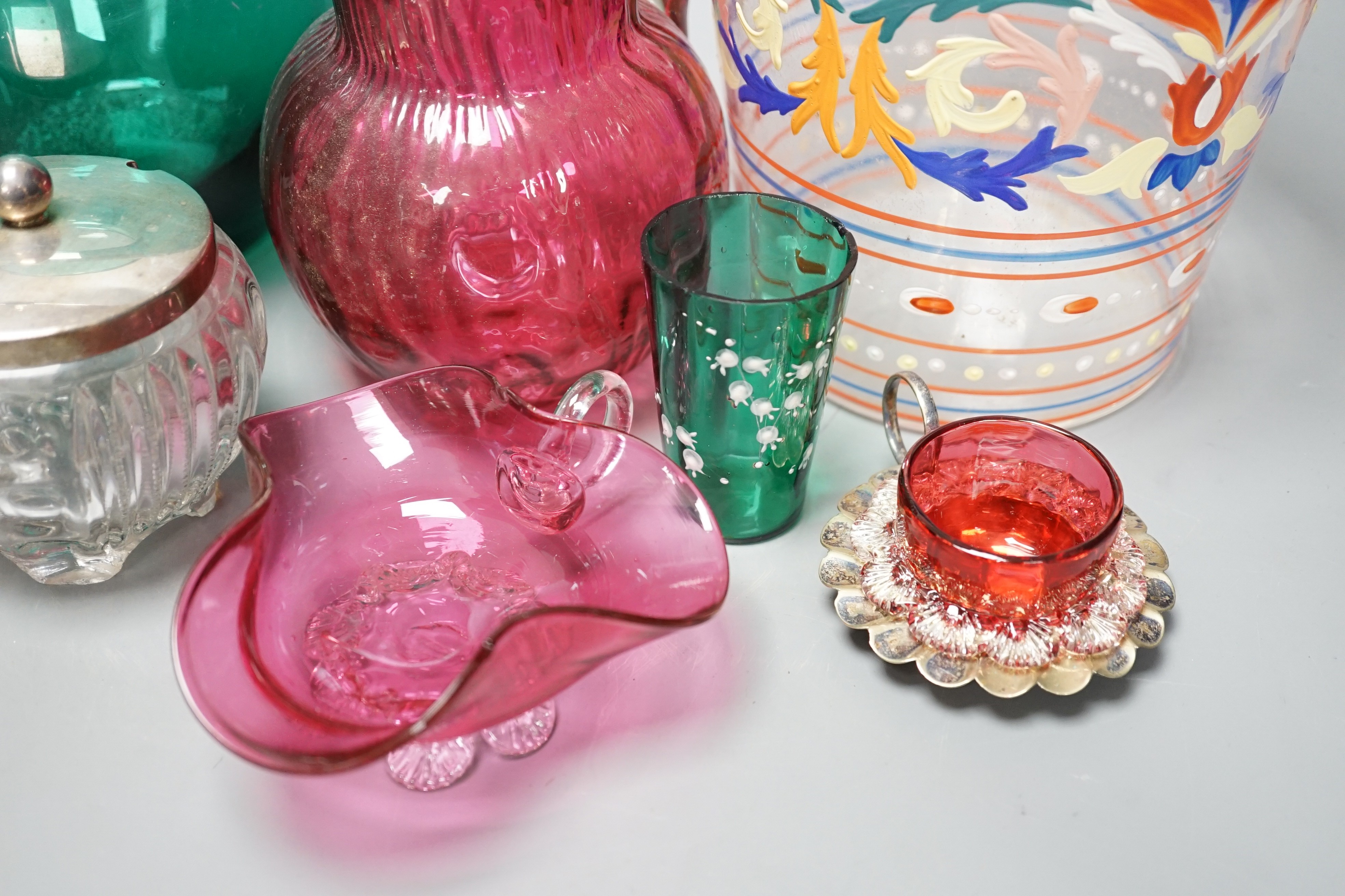 A collection of cranberry glass, a silver lidded glass sugar bowl, and enamelled glass historismus humpen etc